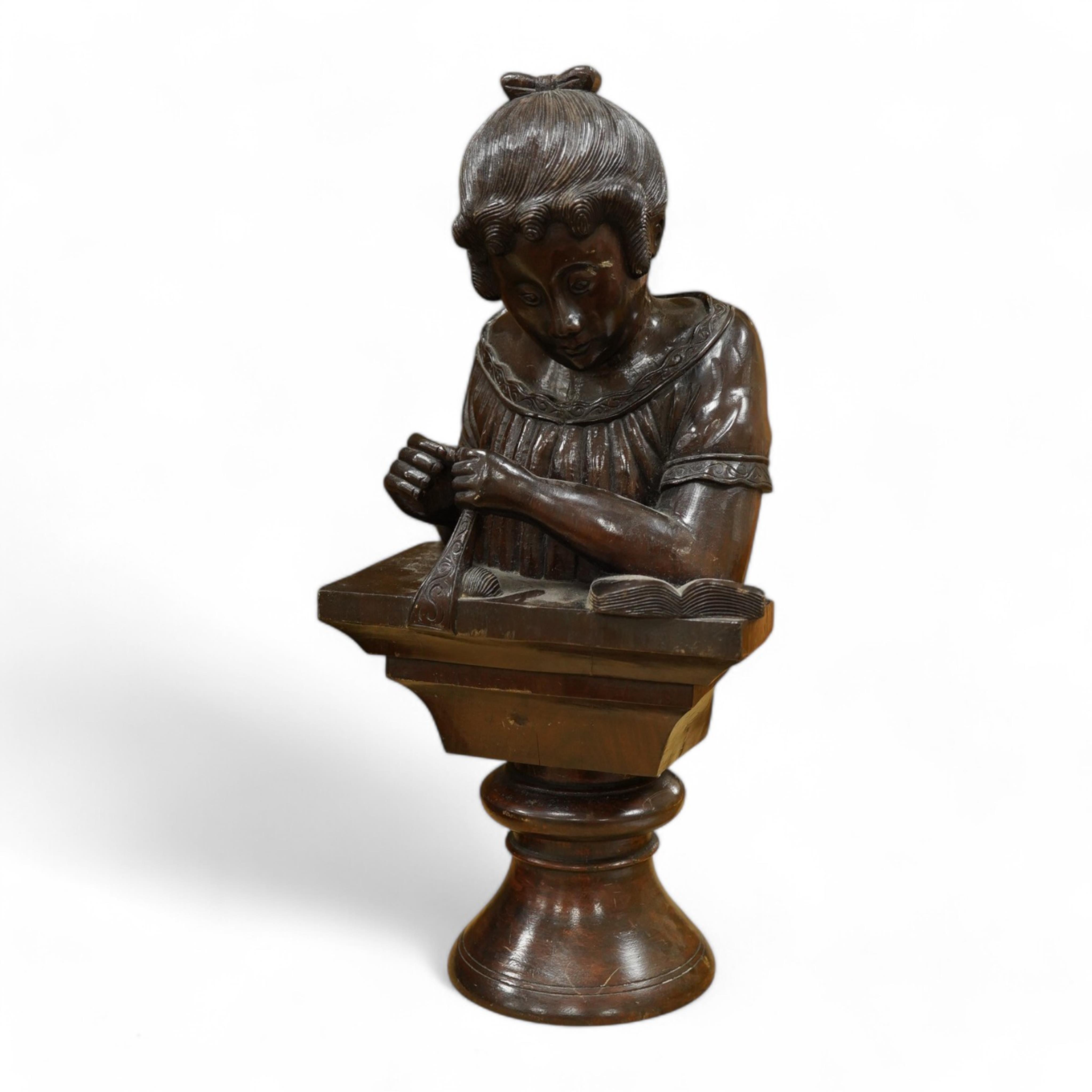 A carved wood bust of a girl sewing, 47cm high. Condition - two old cracks to the back of carving